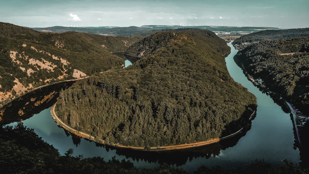 brown and green mountain beside blue body of water during daytime