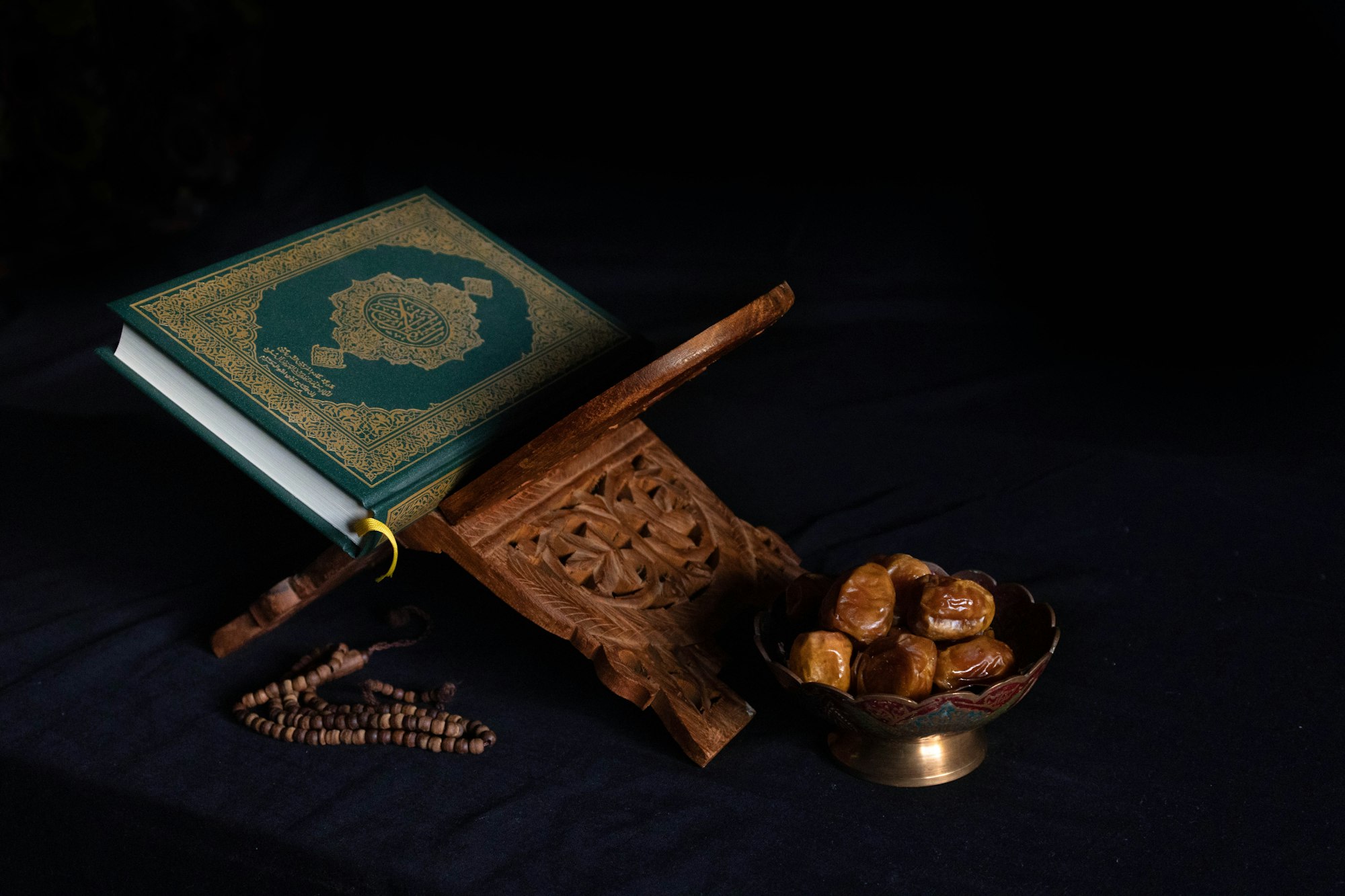 Quran The Holy Book and a Bowel of Dates, Dark Background