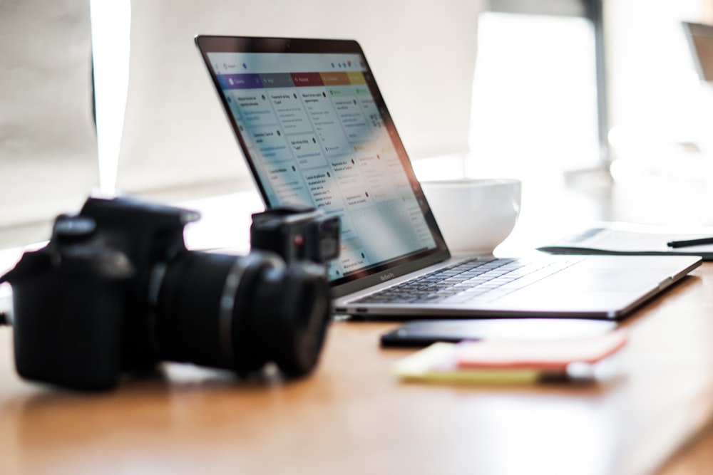 black dslr camera on brown wooden table