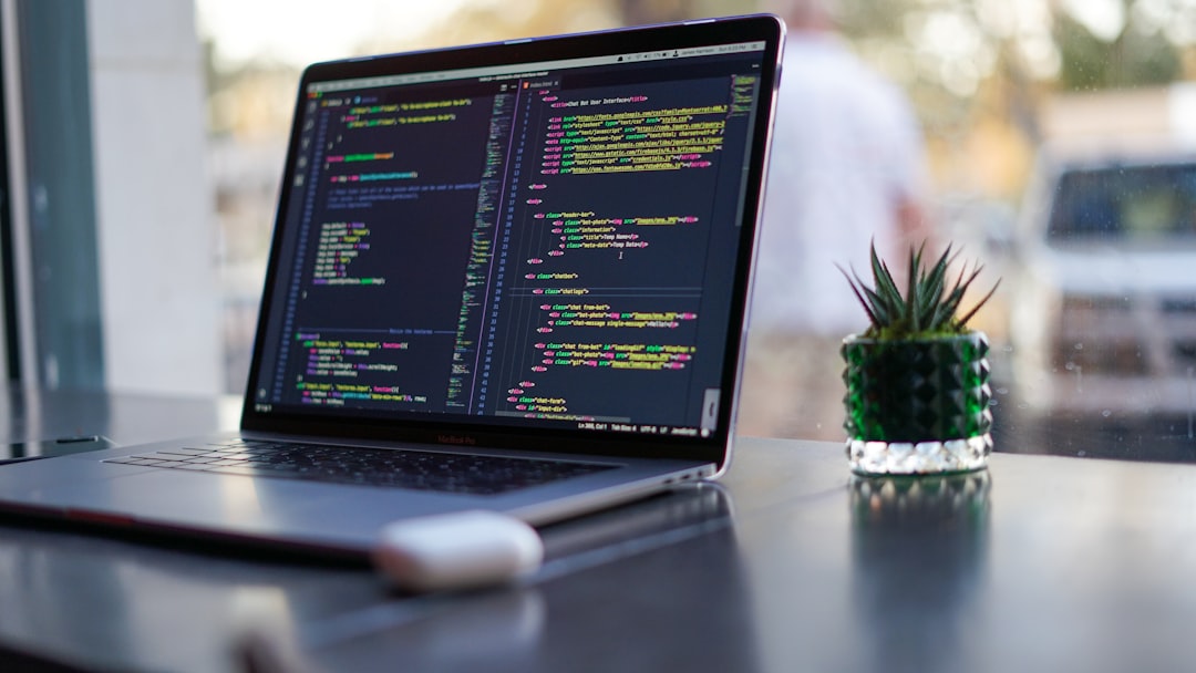 Laptop with code and plant in coffee shop