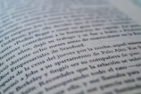 A close-up view of a page from a book with text in a language similar to Spanish. The focus is on specific lines that mention locations like Stanford and Palo Alto, while the rest of the text gradually blurs towards the edges.
