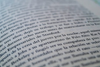 A close-up view of a page from a book with text in a language similar to Spanish. The focus is on specific lines that mention locations like Stanford and Palo Alto, while the rest of the text gradually blurs towards the edges.