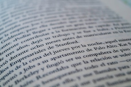 A close-up view of a page from a book with text in a language similar to Spanish. The focus is on specific lines that mention locations like Stanford and Palo Alto, while the rest of the text gradually blurs towards the edges.