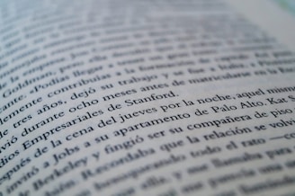 A close-up view of a page from a book with text in a language similar to Spanish. The focus is on specific lines that mention locations like Stanford and Palo Alto, while the rest of the text gradually blurs towards the edges.