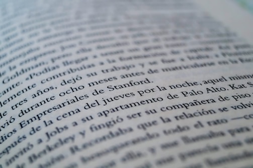 A close-up view of a page from a book with text in a language similar to Spanish. The focus is on specific lines that mention locations like Stanford and Palo Alto, while the rest of the text gradually blurs towards the edges.