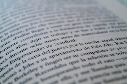 A close-up view of a page from a book with text in a language similar to Spanish. The focus is on specific lines that mention locations like Stanford and Palo Alto, while the rest of the text gradually blurs towards the edges.
