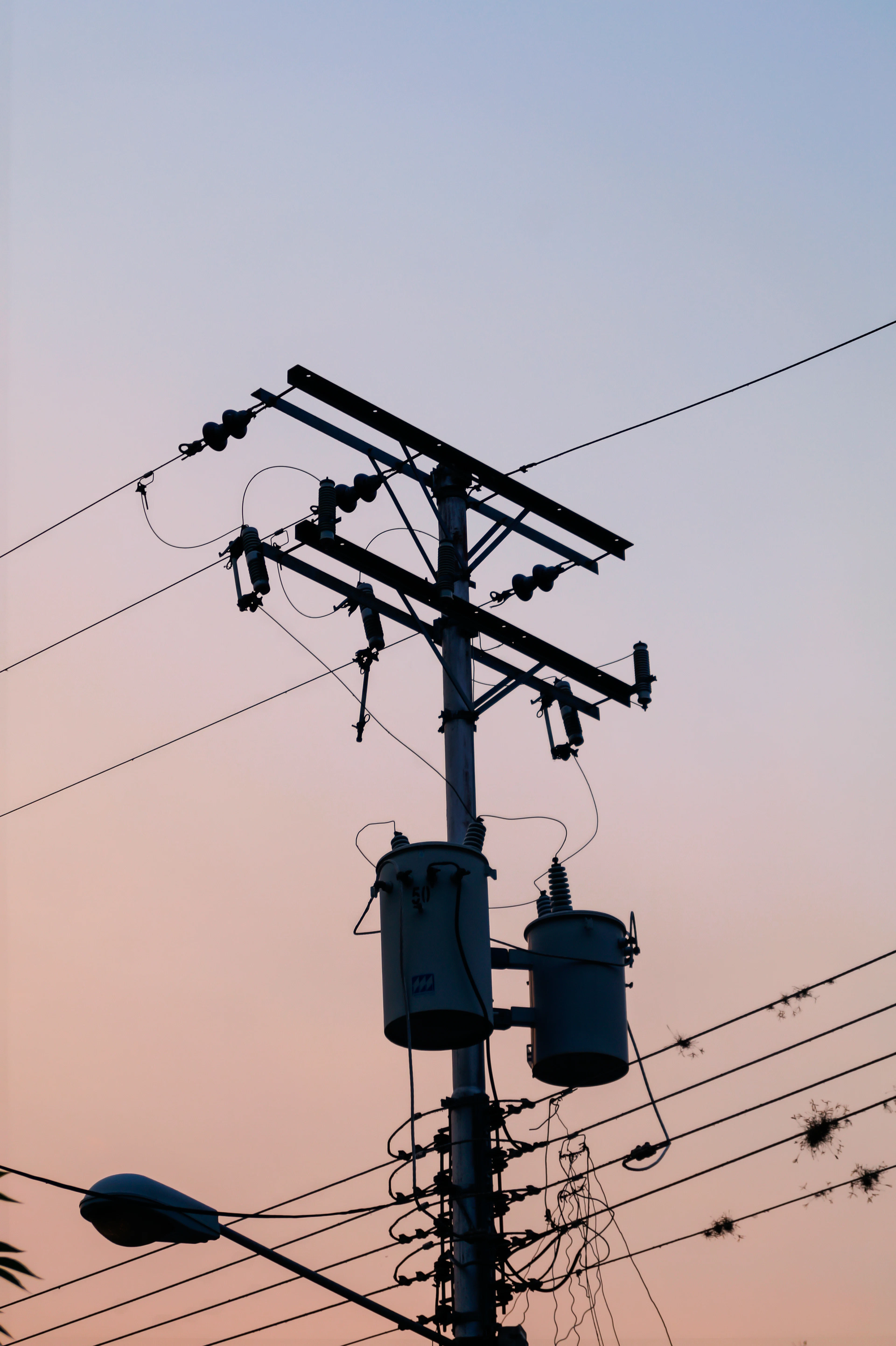 Electricity pole with transformers at dusk