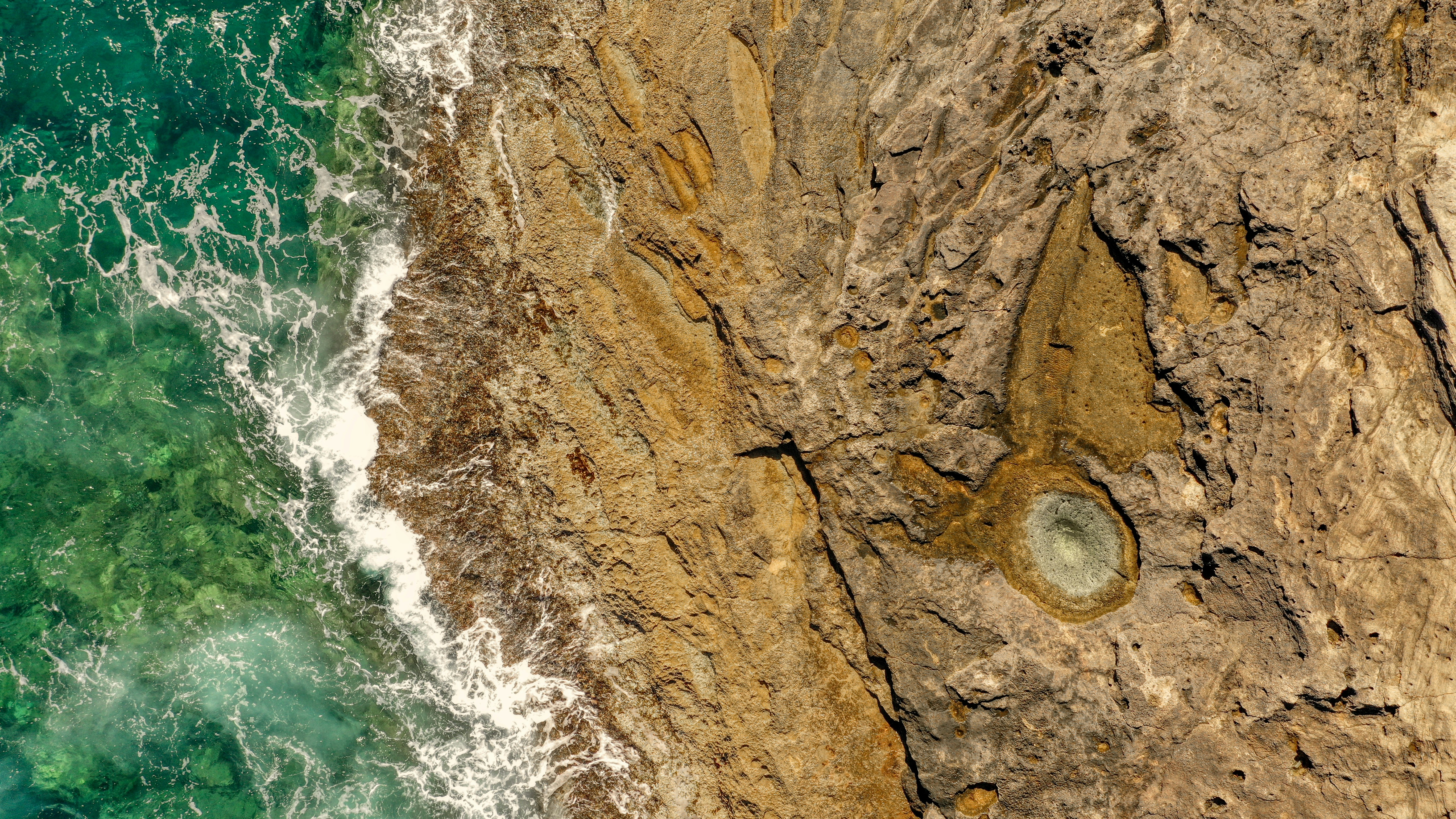 Formation rocheuse brune à côté d’un plan d’eau pendant la journée
