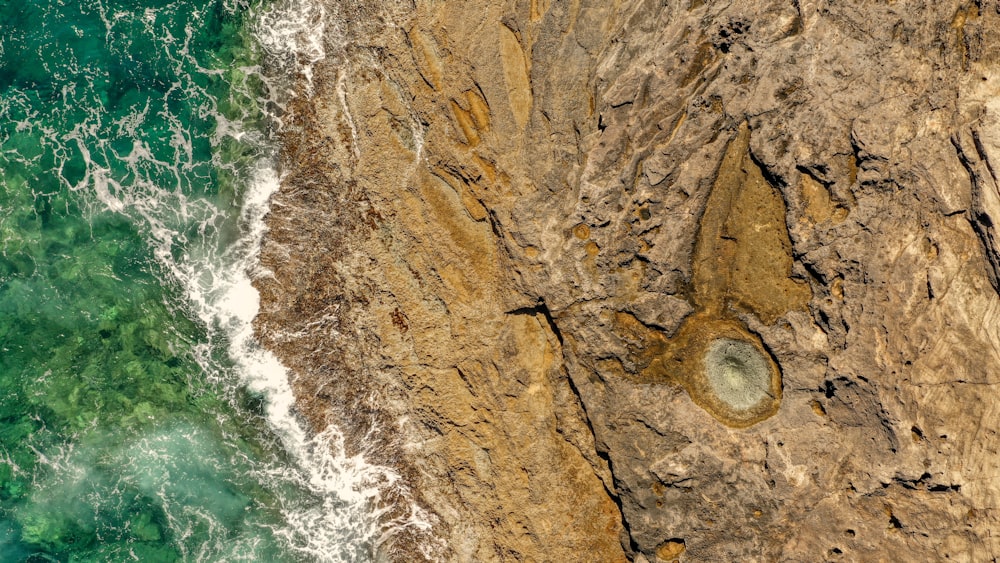 brown rock formation beside body of water during daytime