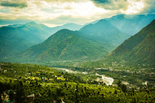 green mountains under white clouds during daytime in Manali India