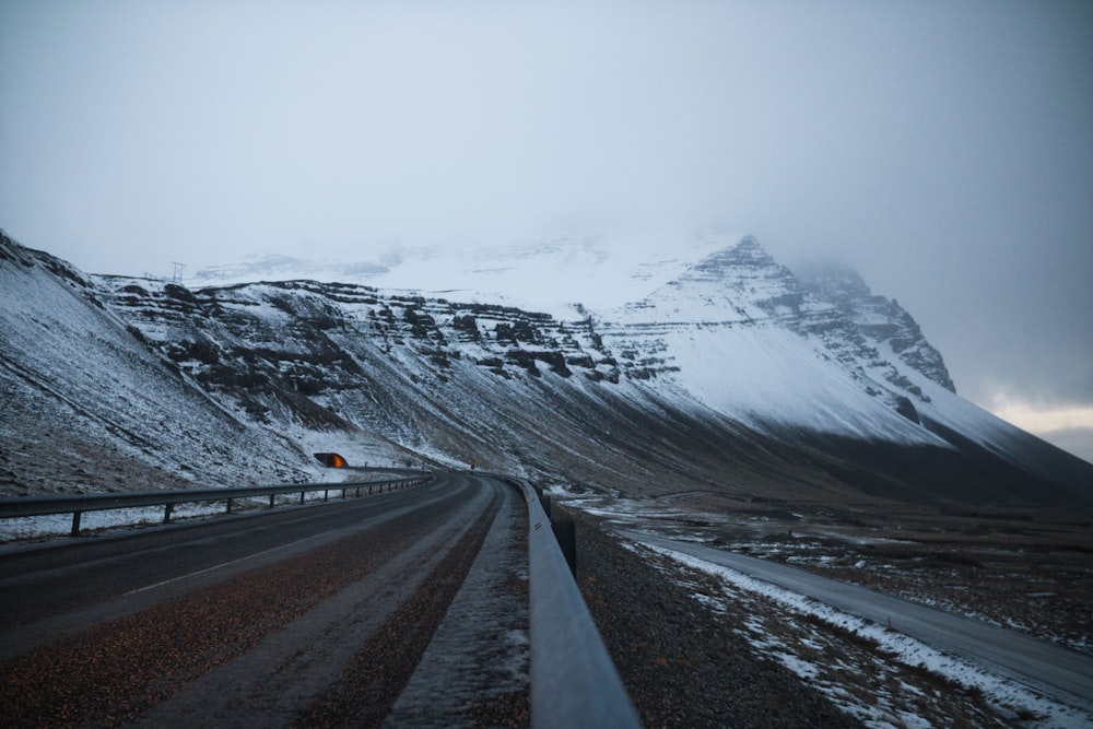 black asphalt road near snow covered mountain during daytime