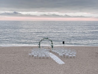 An intimate beachside wedding setup with soft lighting and elegant floral arrangements.