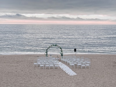 A vibrant wedding setup on the beach with handcrafted decorations and soft lighting at sunset.
