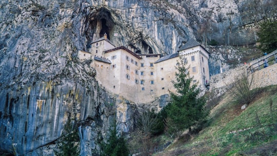 white concrete building on cliff in Predjama Castle Slovenia