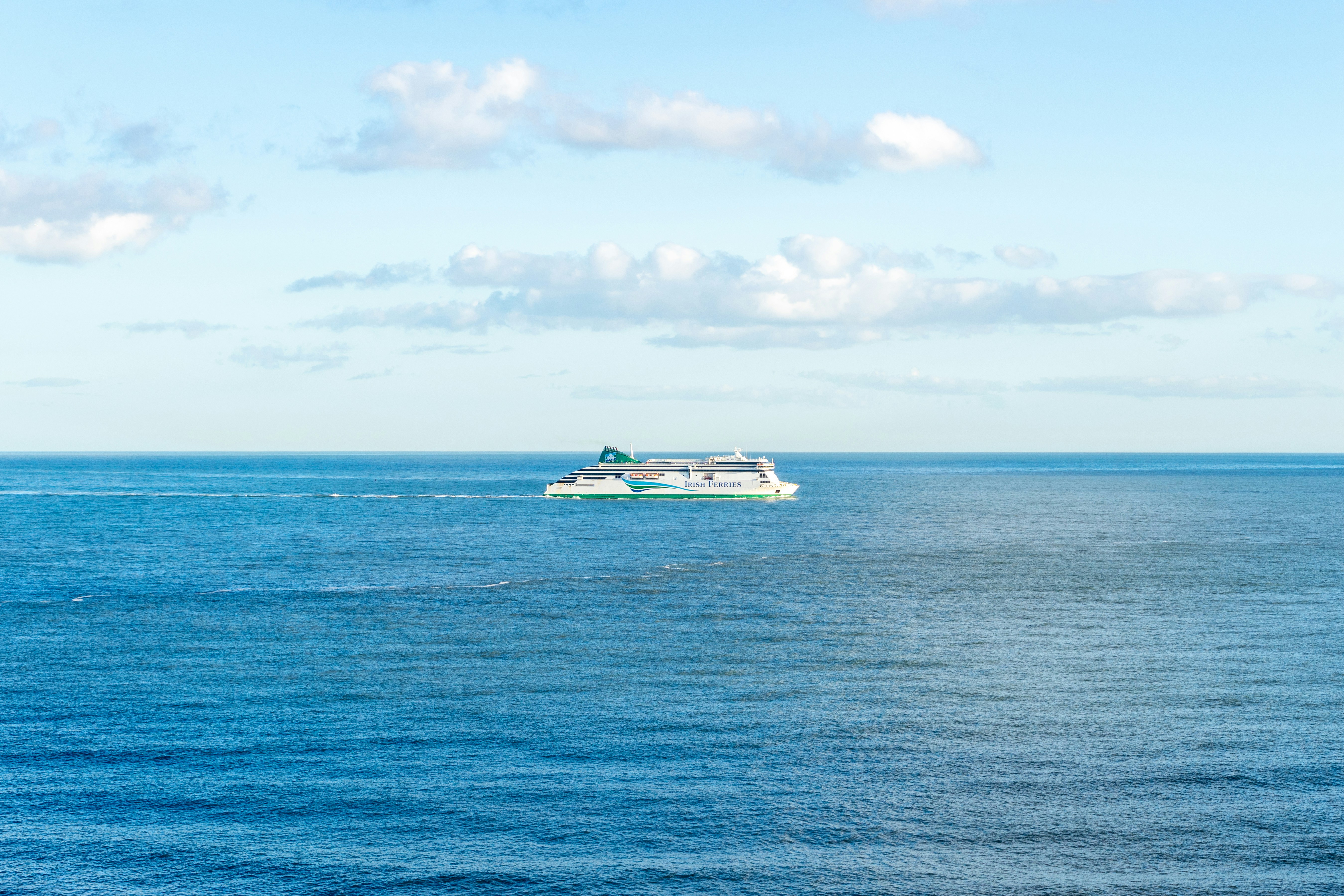 white and blue boat on sea under blue sky during daytime dublin teams background