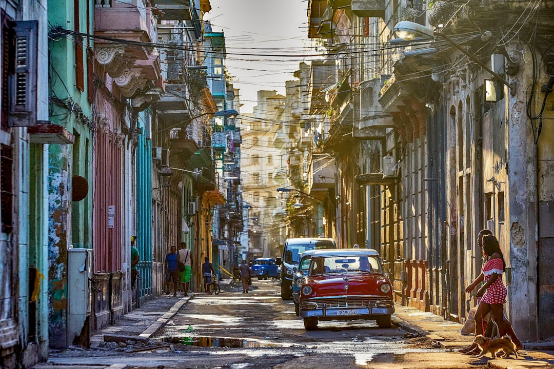 red van on road in between buildings during daytime