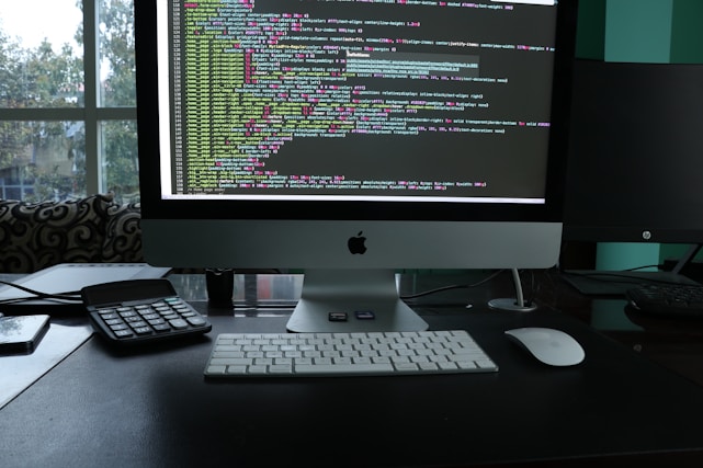 Sleek modern workspace with a coder developing innovative software on multiple screens.