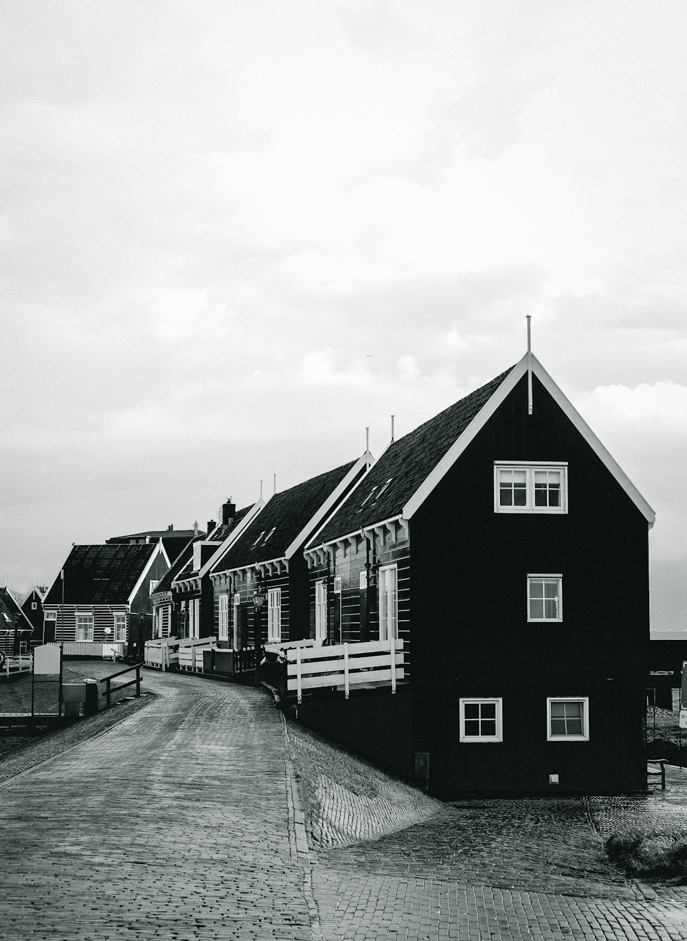 grayscale photo of houses under cloudy sky