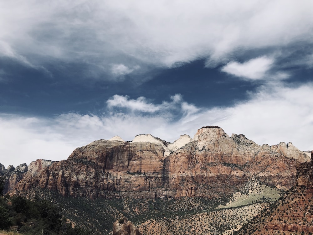 brown rocky mountain under cloudy sky during daytime