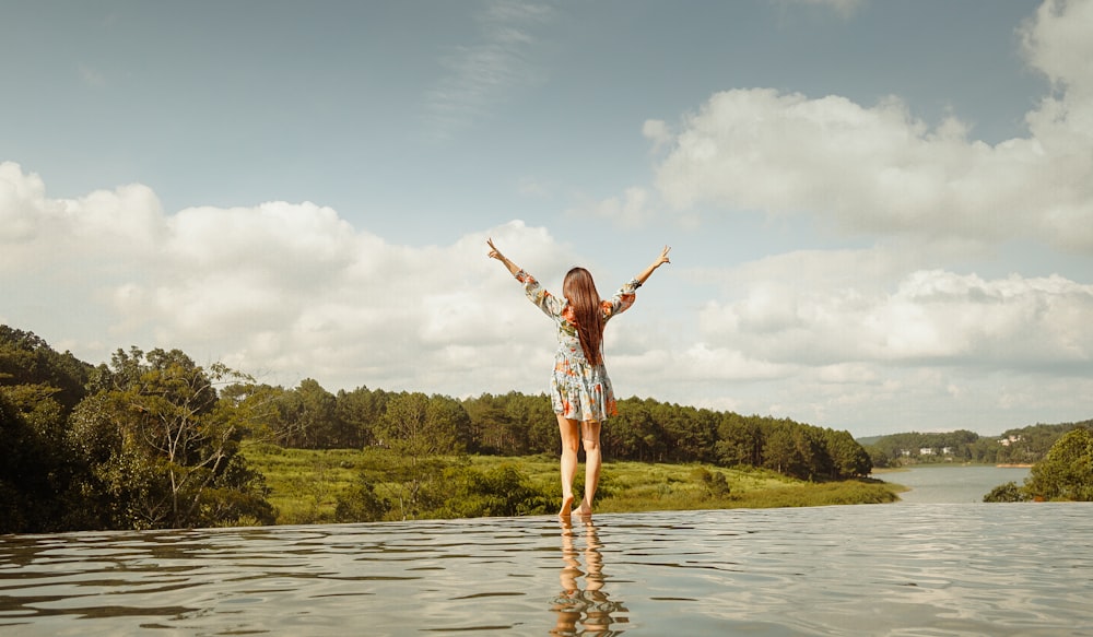 Femme en chemise à carreaux rouge et blanc et short blanc debout sur l’eau pendant la journée