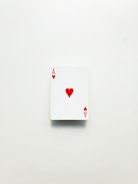 A single playing card with a white background. The card is the ace of hearts with a red heart symbol at the center and red letter A in the corners.