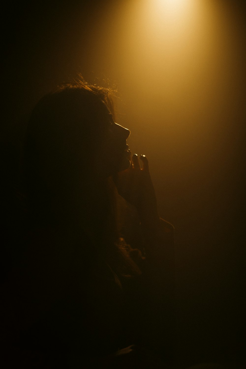 silhouette of woman covering her face with her hand