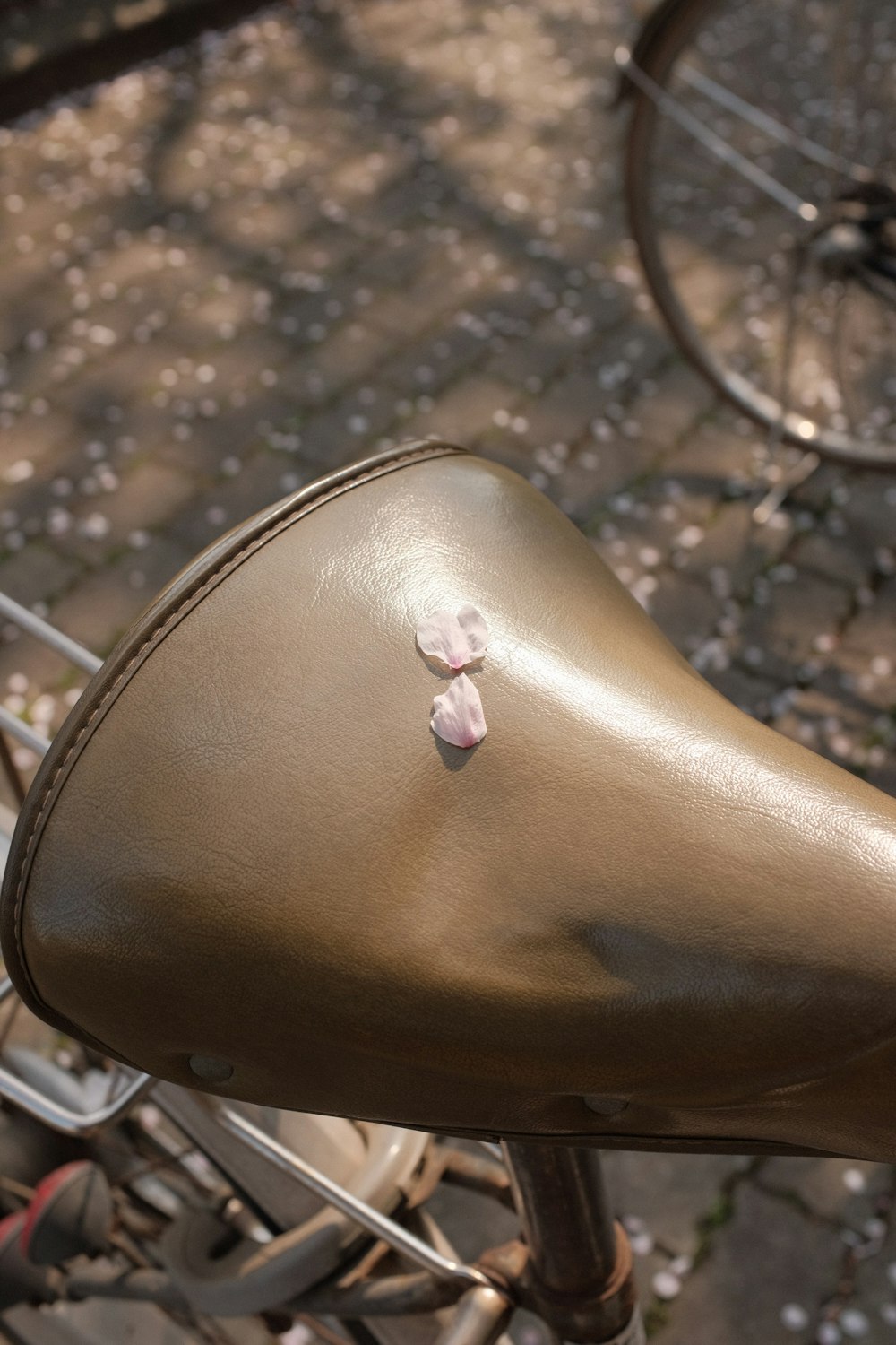 brown leather shoe with pink and white flower accent