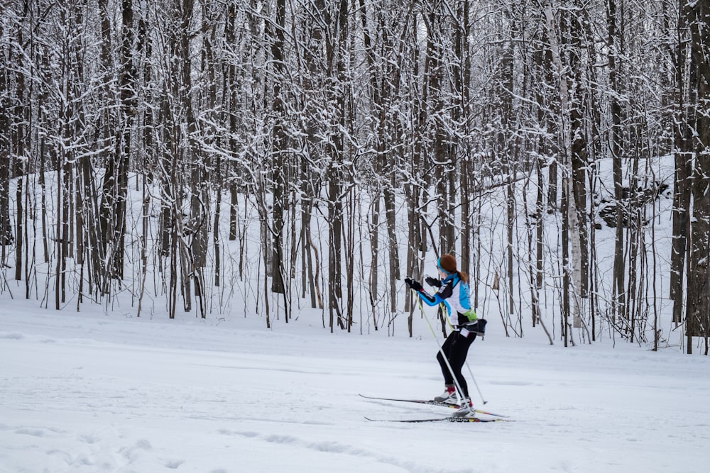 2 person in green jacket and black pants riding ski blades on snow covered ground during