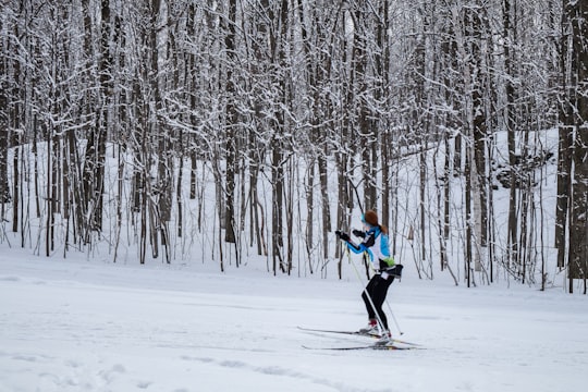 2 person in green jacket and black pants riding ski blades on snow covered ground during in Mont Saint-Bruno Canada