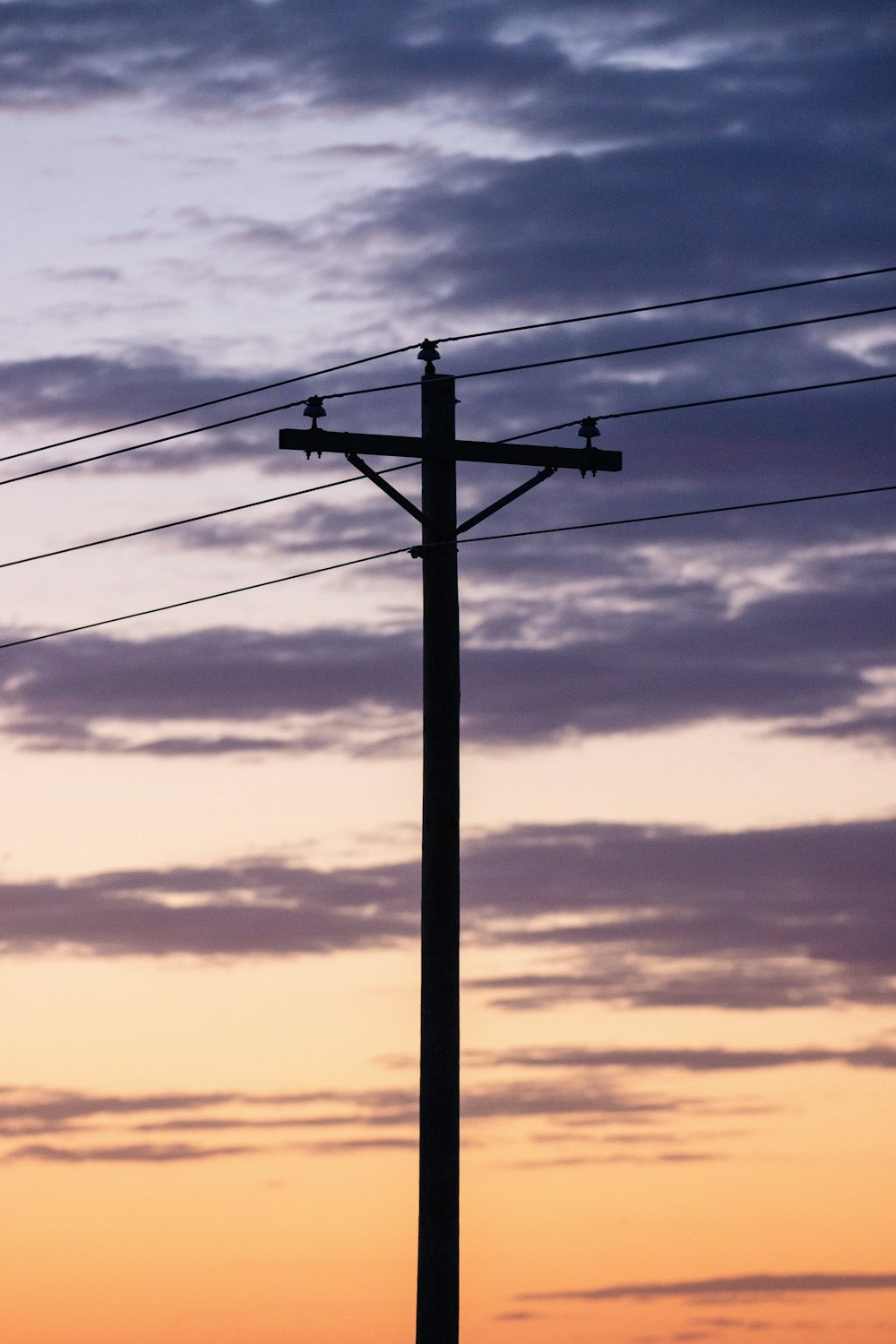 black electric post under cloudy sky during daytime