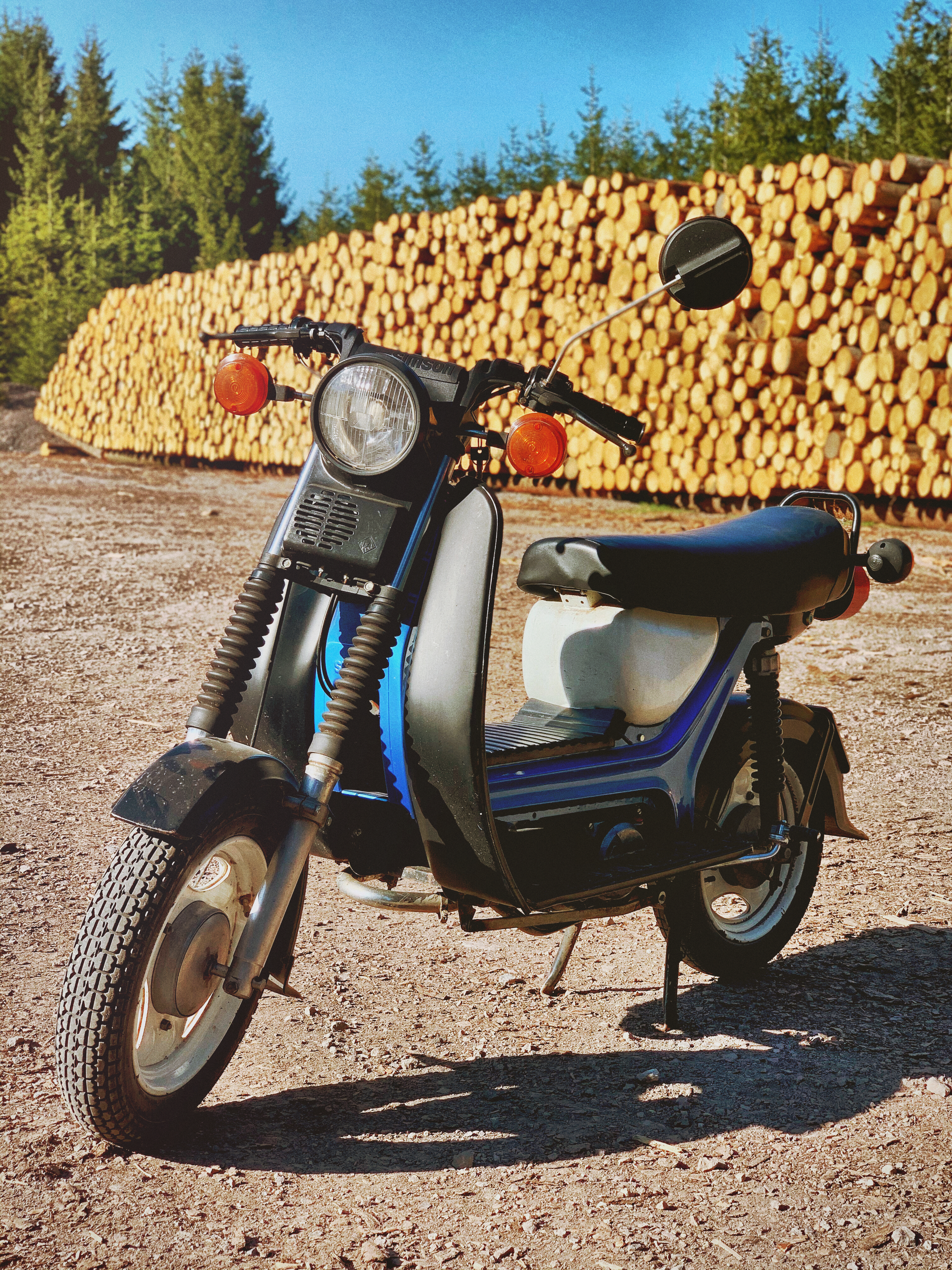 Moto bleue et noire garée à côté de foin brun