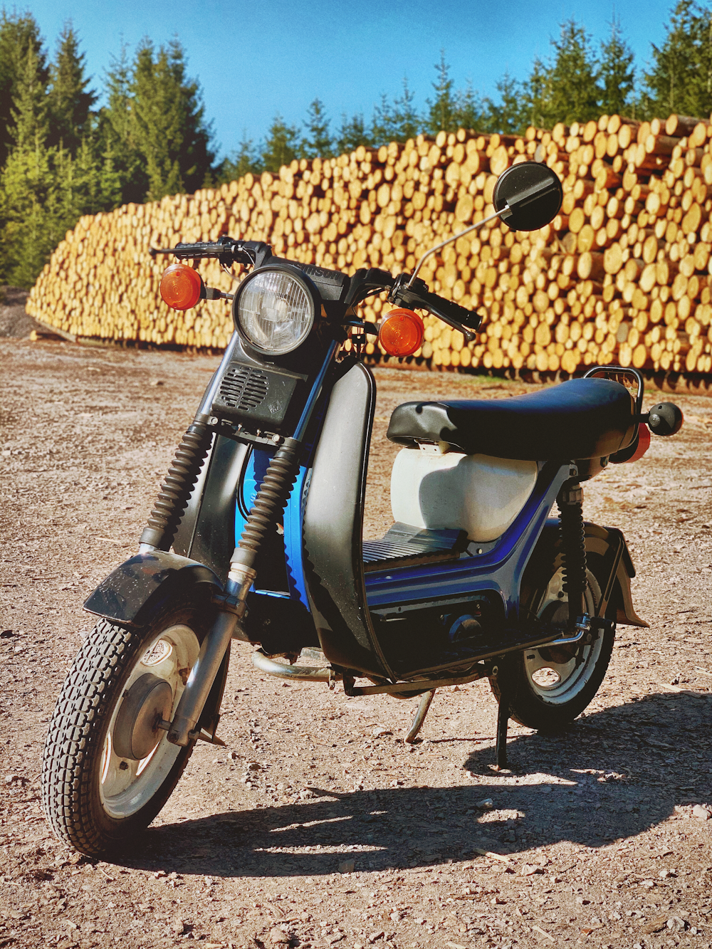 blue and black motorcycle parked beside brown hay