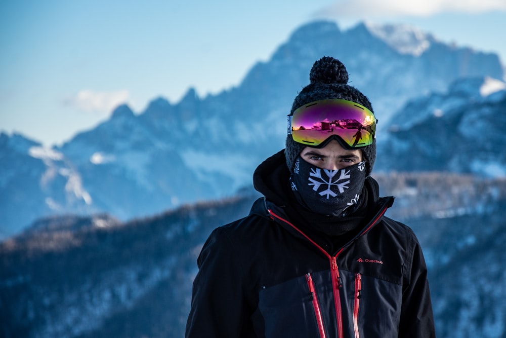 person in black jacket wearing green goggles