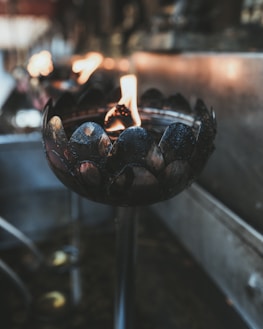 Close-up of a traditional lamp lit during evening prayers inside the temple.
