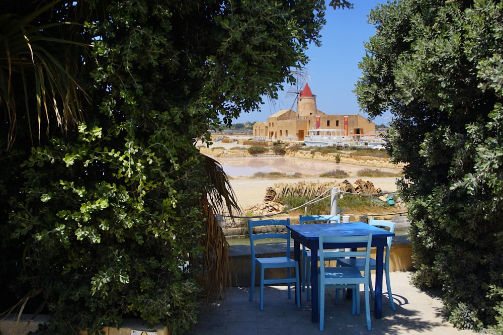 blue plastic table and chairs on beach during daytime