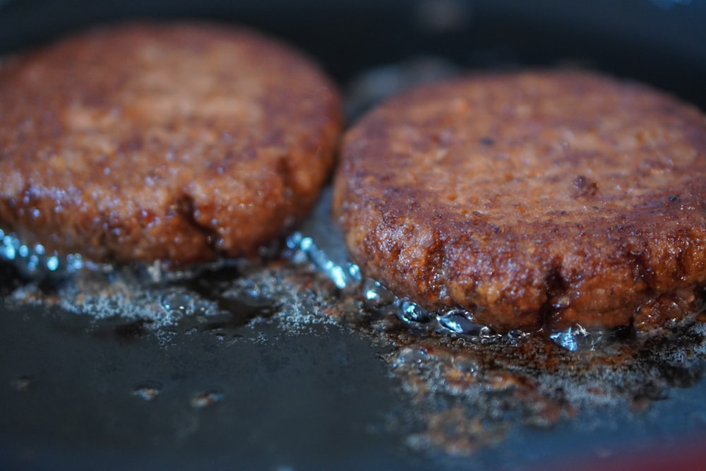 three brown cookies on black surface