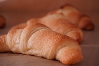 Freshly baked croissants with flaky layers stacked on a linen cloth
