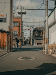 man in black jacket riding bicycle on road during daytime