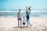 A happy family enjoying a beach vacation with clear blue skies.