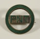 a green and gold pin with the word pint on it