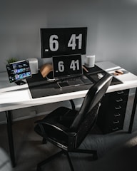 black and white wooden desk with black laptop computer