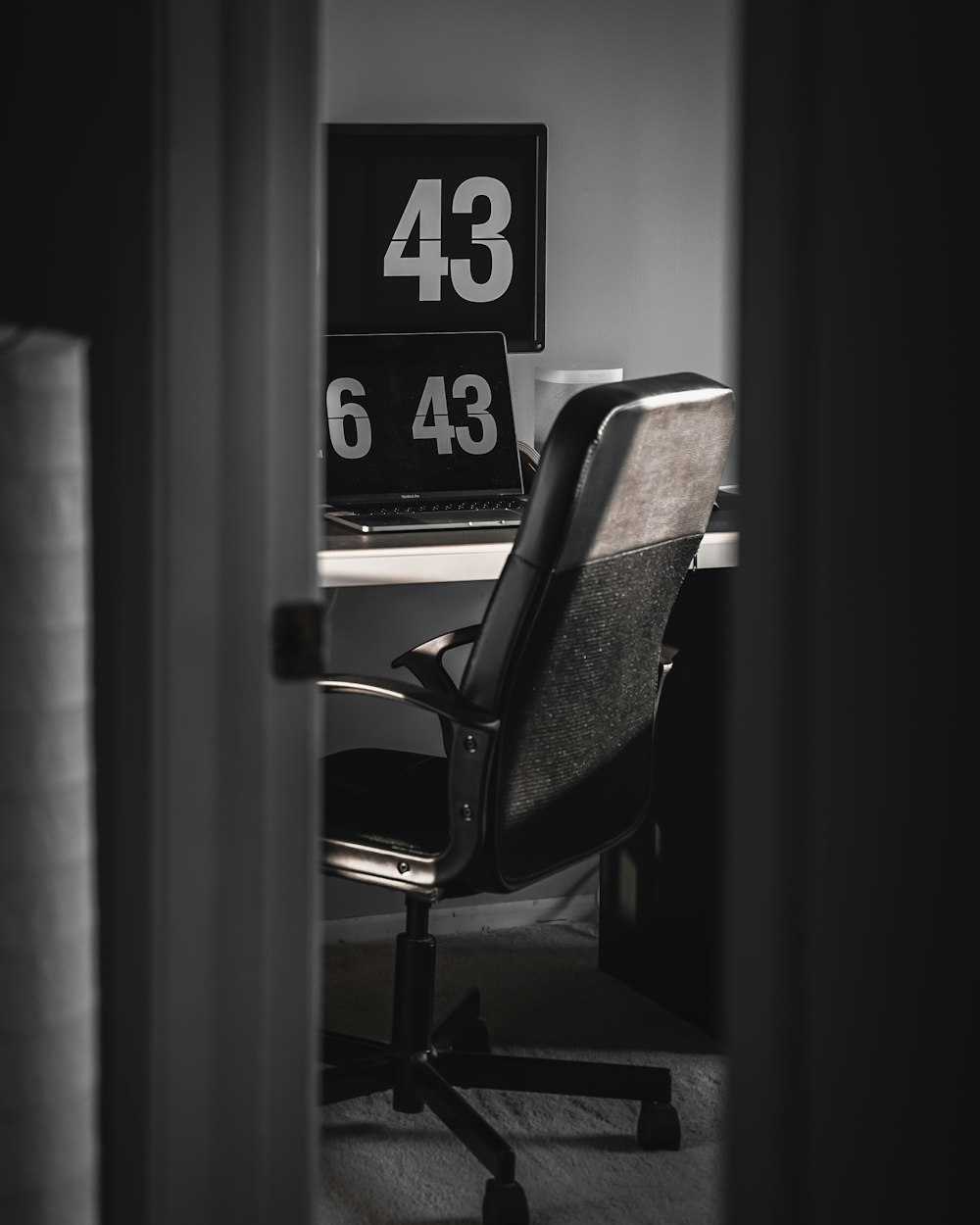 black and brown armchair beside black wall