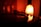 A warm, dimly lit scene with a glowing salt lamp casting an orange hue. A vinyl record player with its tonearm poised engages gently with the record. The ambiance is cozy and nostalgic.
