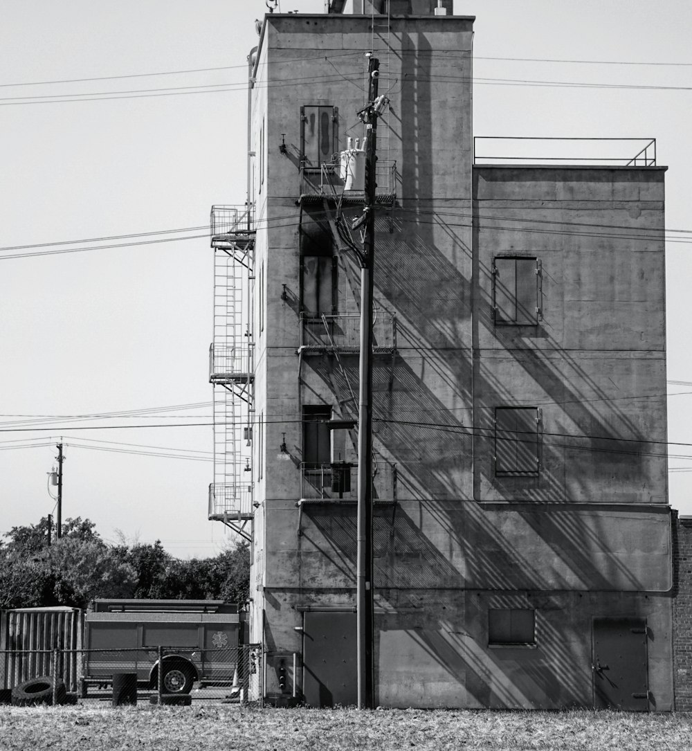grayscale photo of building near road with cars