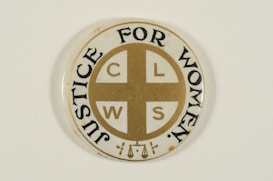 A circular pin badge with a gold cross dividing the letters 'C', 'L', 'W', 'S' in each quadrant. Surrounding the cross, the words 'Justice For Women' are printed in bold black text. The badge background is predominantly white, with a subtle decorative element at the bottom.
