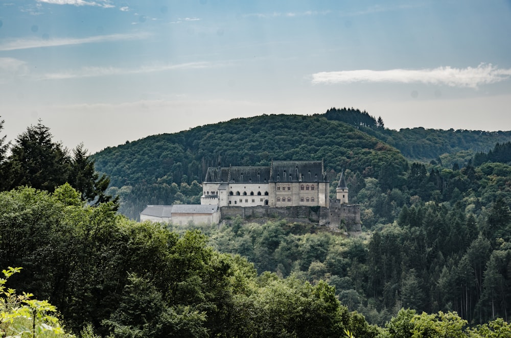 white concrete building on top of green mountain during daytime