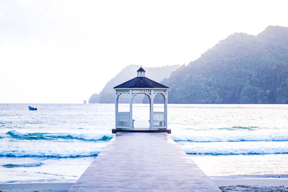 gazebo de madeira branca na doca de madeira marrom durante o dia