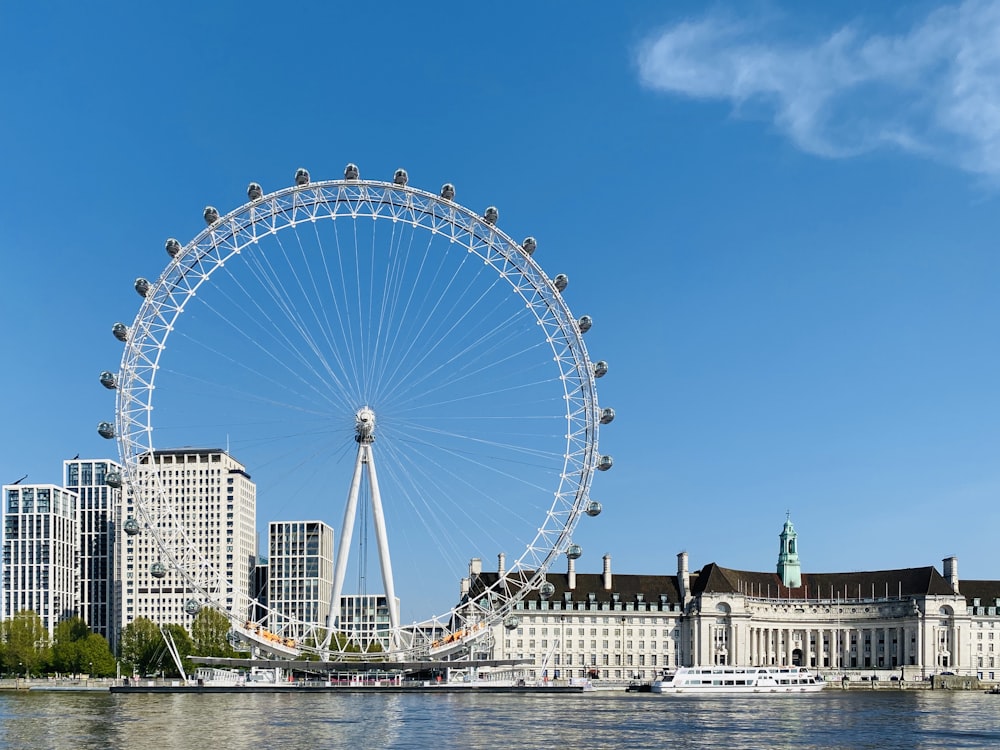 ruota panoramica bianca vicino a un edificio in cemento bianco sotto il cielo blu durante il giorno