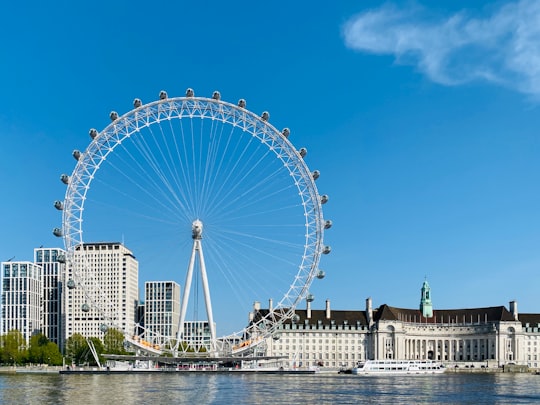 white ferris wheel near white concrete building under blue sky during daytime in London Eye United Kingdom