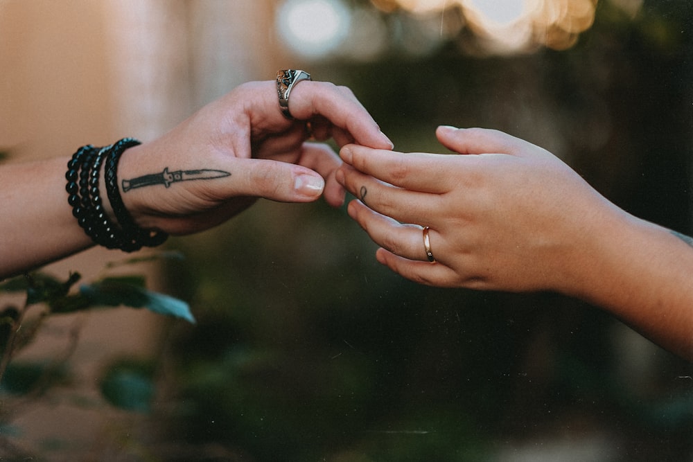 person wearing silver ring and black bracelet